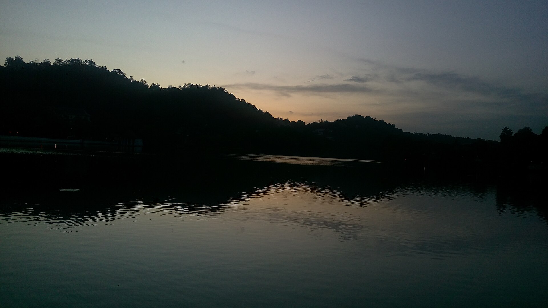Kandy Lake in the morning with the temple skyline reflected, Sri Lanka